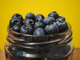 A jar filled with blueberries, a close-up of a blueberry
