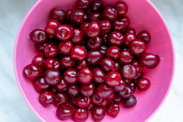 washed cherries in a pink plastic bowl