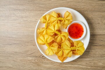 Deep Fried Bow Wontons in white plate on wooden background