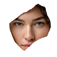 Close-up view of a woman's face with striking eyes and soft features emerging from a torn paper background for artistic concepts