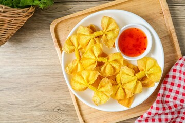 Deep Fried Bow Wontons in white plate on wooden background