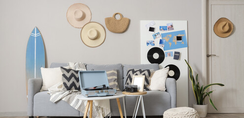 Interior of stylish living room with grey sofa, record player and mood board