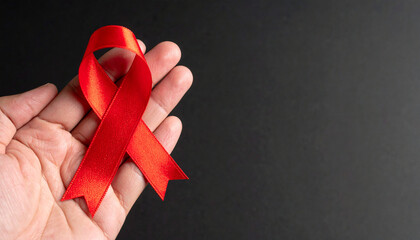 Hand holding red awareness ribbon. HIV, AIDS, heart disease, substance abuse.