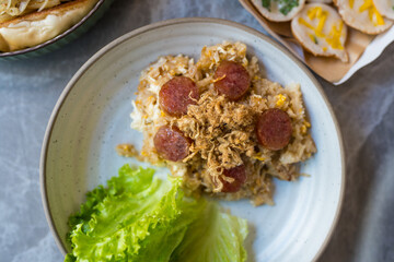 Top view of fried rice topped with sliced chinese sausage and dried shredded pork. Thai food