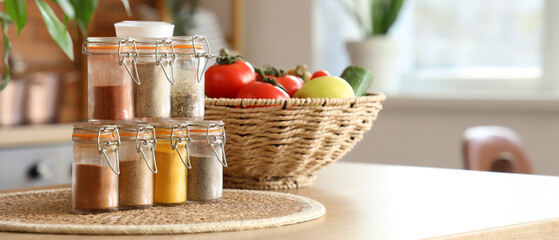 Jars with different spices on table in kitchen, closeup
