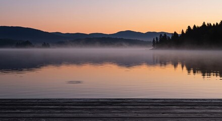 Fototapeta premium Serene lake reflecting the colorful sky at dusk with mountains in the distance