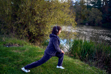 middle-aged woman exercising and switching music in her wireless headphones using her phone during...
