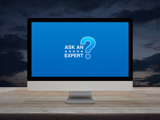 Ask an expert with star and question mark sign icon on computer monitor screen on wooden table over...