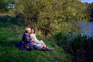 middle-aged daughter and an elderly mother together on a picnic in the autumn forest