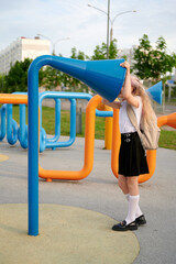 woman interacting with colorful playground installation, featuring blue and orange structures, in...