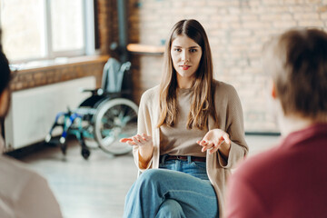 Psychologist leading support group meeting for people with disabilities