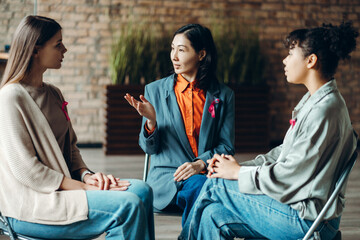 Doctor explaining breast cancer awareness to women during meeting