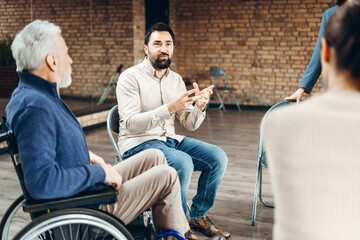 Psychologist leading group therapy session for patients with disabilities