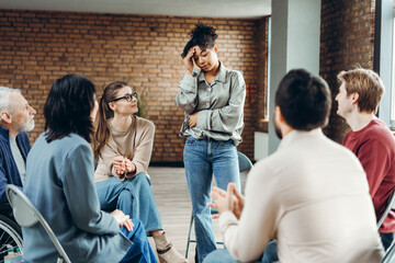Sad African American woman sharing problems during group therapy session