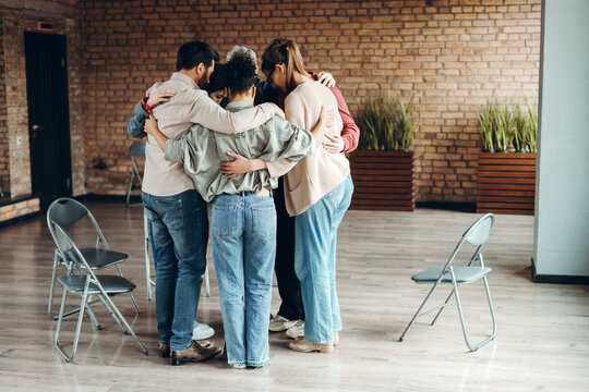 Team members hugging each other during support group meeting