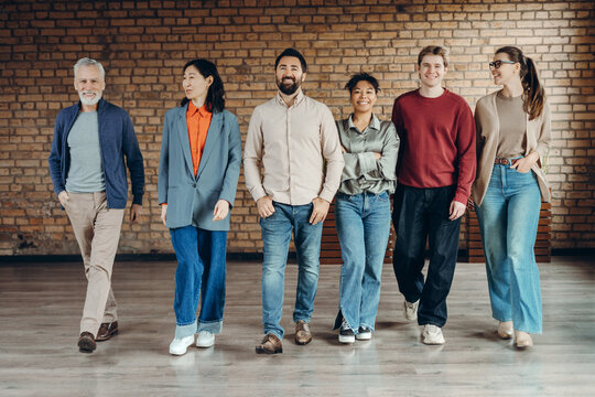 Diverse group of smiling business team walking together in modern office