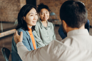 Psychotherapist comforting patient during group therapy session