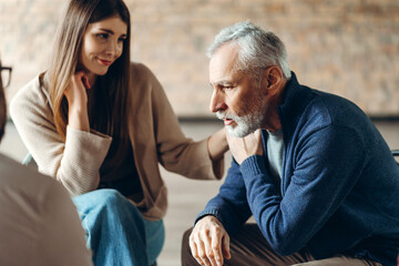 Psychologist comforting senior man during therapy session
