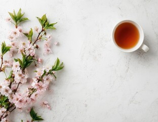 Delicate spring blossoms and teacup on a light surface