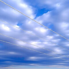 Diagonal Power Lines Against a Cloudy Blue Sky