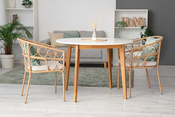 Beautiful interior of modern living room with table, armchairs, comfortable sofa, houseplants and shelving unit