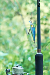Close-up of a fishing rod and a wobbler for fishing. Spinning rods for sport fishing. Vertical photo