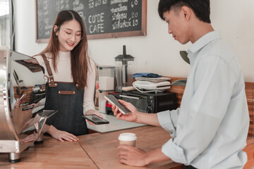 Young adults engaging in seamless payment exchange at indoor social hub with customer interaction
