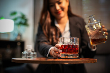 Closeup business woman holding a glass of whiskey
