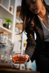  Closeup business woman holding a glass of whiskey