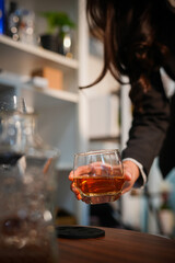  Closeup business woman holding a glass of whiskey