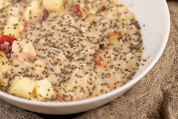 chia in oatmeal with fruits close up, quickly cooked oatmeal porridge with fruits and berries and...