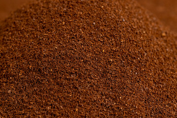 an abstract uneven background of ground coffee beans for making a high-quality and aromatic coffee drink, closeup