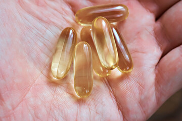 Oil pills in hand. Capsules with evening primrose, Omega and fish oil.