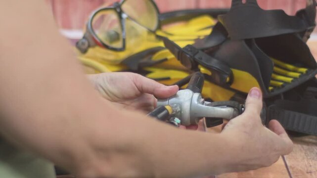 Woman Hands Getting ready to scuba dive. Verify toric board of the diving regulator, checking the O-ring. Keep it clean and precise