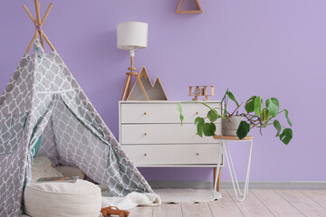 Play tent, chest of drawers, houseplant and pouf in interior of modern children's room