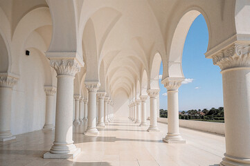 Obraz premium Sunlit arched colonnade under clear blue sky