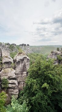 Vertical video, Saxon Switzerland National Park, rocky terrain valley, ugc landscape from height, stone mountains, hills and forest serenity.