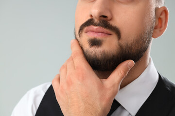 Obraz premium Handsome young bearded man on grey background, closeup
