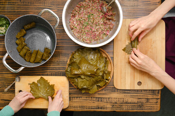 Dolma preparation with grape leaves and meat filling at a home kitchen