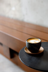 Cup of milk latte coffee on table by the street.