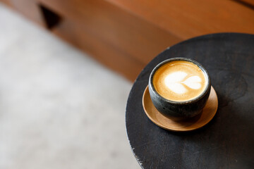 Cup of milk latte coffee on table by the street.