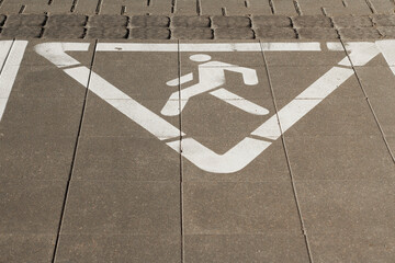 Pedestrian road sign painted on asphalt surface indicating safety for walkers in urban areas