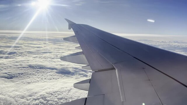Blick aus einem Flugzeug &uuml;ber weitreichende Wolkenlandschaften mit einem blauen Himmel im Hintergrund