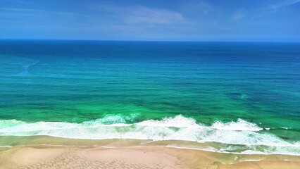 Immerse yourself in the breathtaking beauty of an idyllic tropical beach featuring clear blue waters and gentle waves