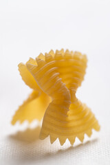 Raw farfalle pasta on white background, Bow-tie shaped pasta, Italian food ingredients