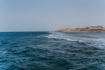 Deep blue ocean waves crashing on sandy beach in egypt