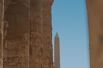 Karnak temple columns framing obelisk against blue sky
