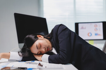 Exhausted businesswoman sleeping on desk at office after working late