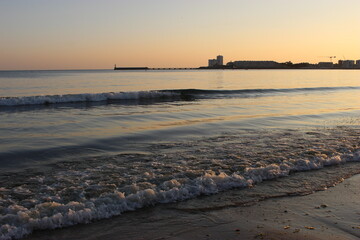 Les Sables-d'Olonne : les jetées et la Chaume au soleil couchant (depuis la Grande Plage)