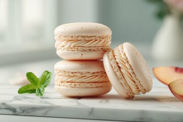 Stack of peach macarons with mint sprig and peach slice on marble surface in soft diffused lighting